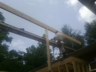 Carpenter setting a ridge beam over a new addition frame — Ice Dam Removal by Roofing Brothers in Hazelwood