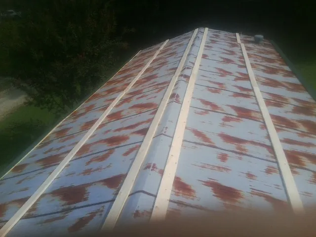 Rusted metal roof panels with new wood purlins before replacement — Storm Damage Roof Repair in Hazelwood by Roofing Brothers