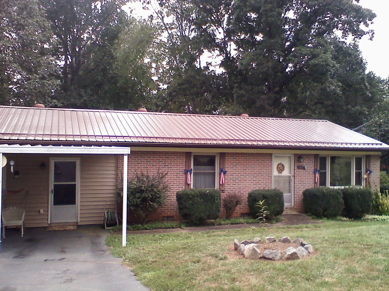 Bronze metal roof and carport on a brick ranch home — Roof Repair work by our crew in Hazelwood
